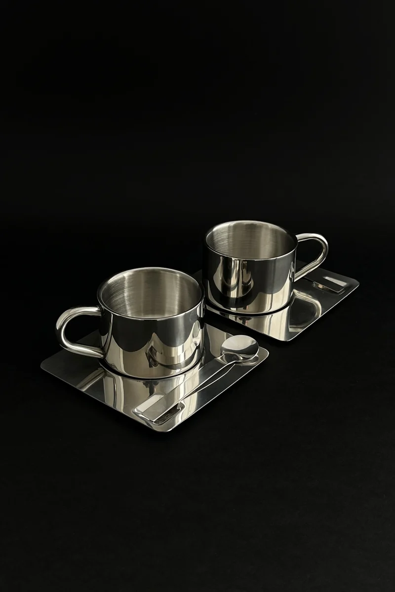 'HEDONISM' stainless steel cup with saucer