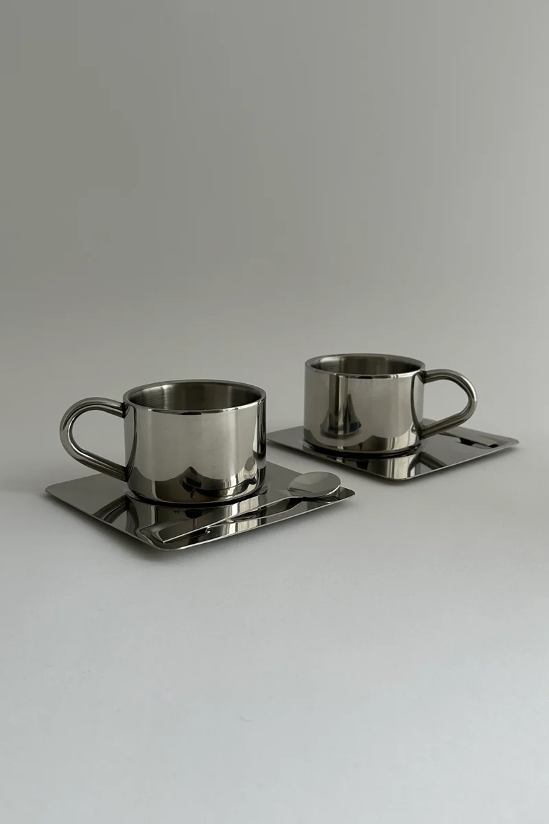 'HEDONISM' stainless steel cup with saucer