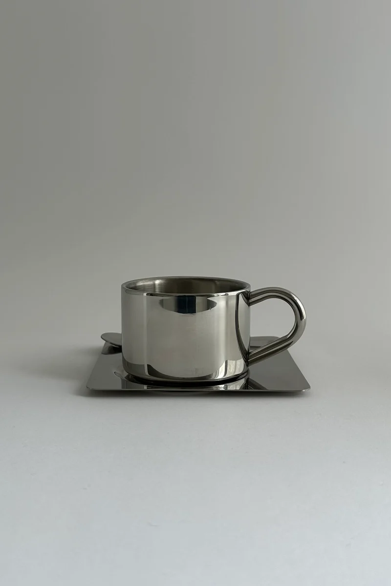 'HEDONISM' stainless steel cup with saucer