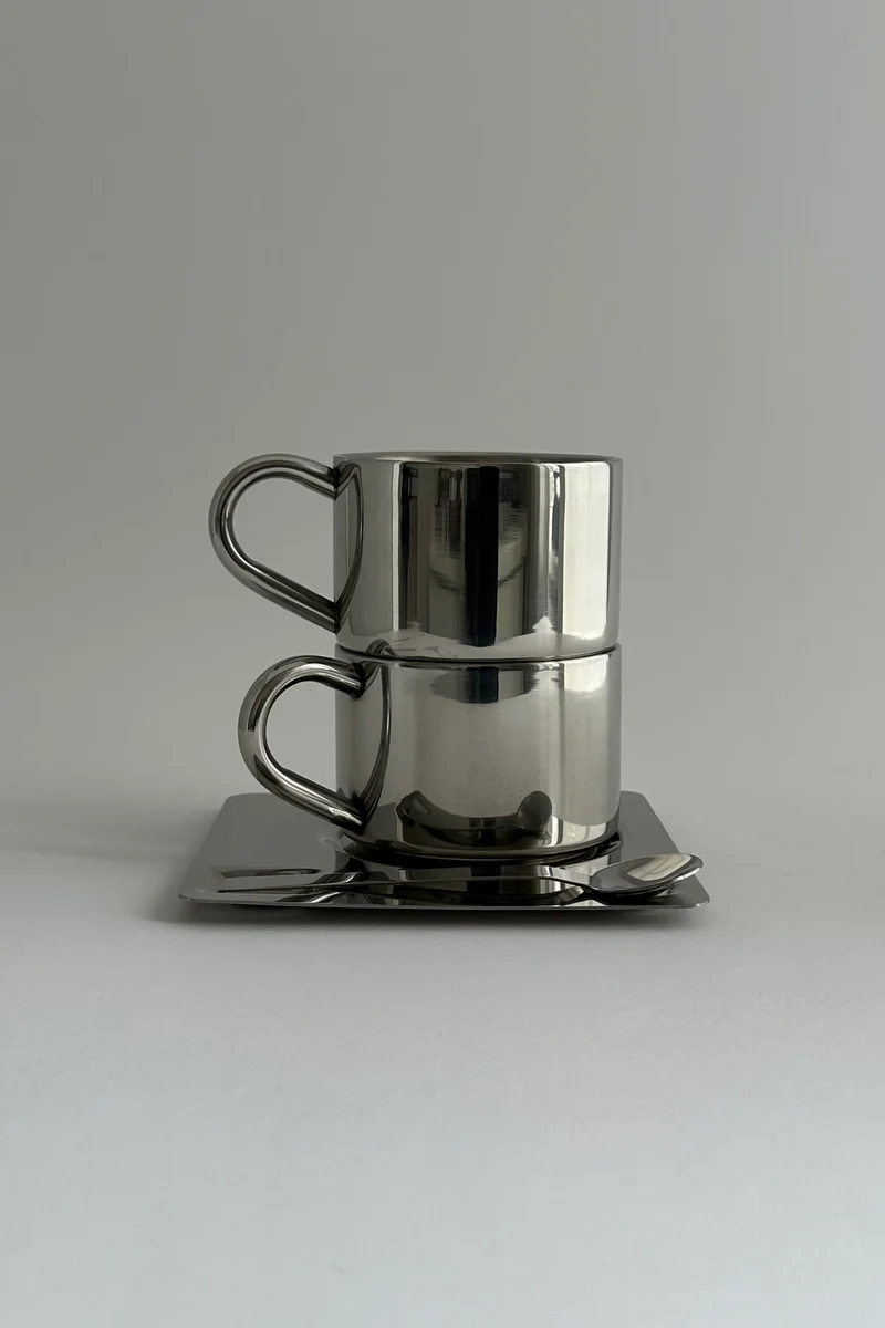 'HEDONISM' stainless steel cup with saucer