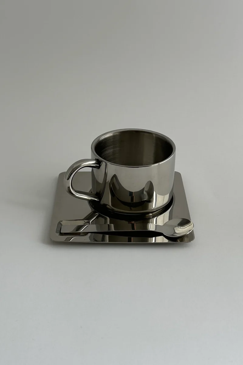 'HEDONISM' stainless steel cup with saucer